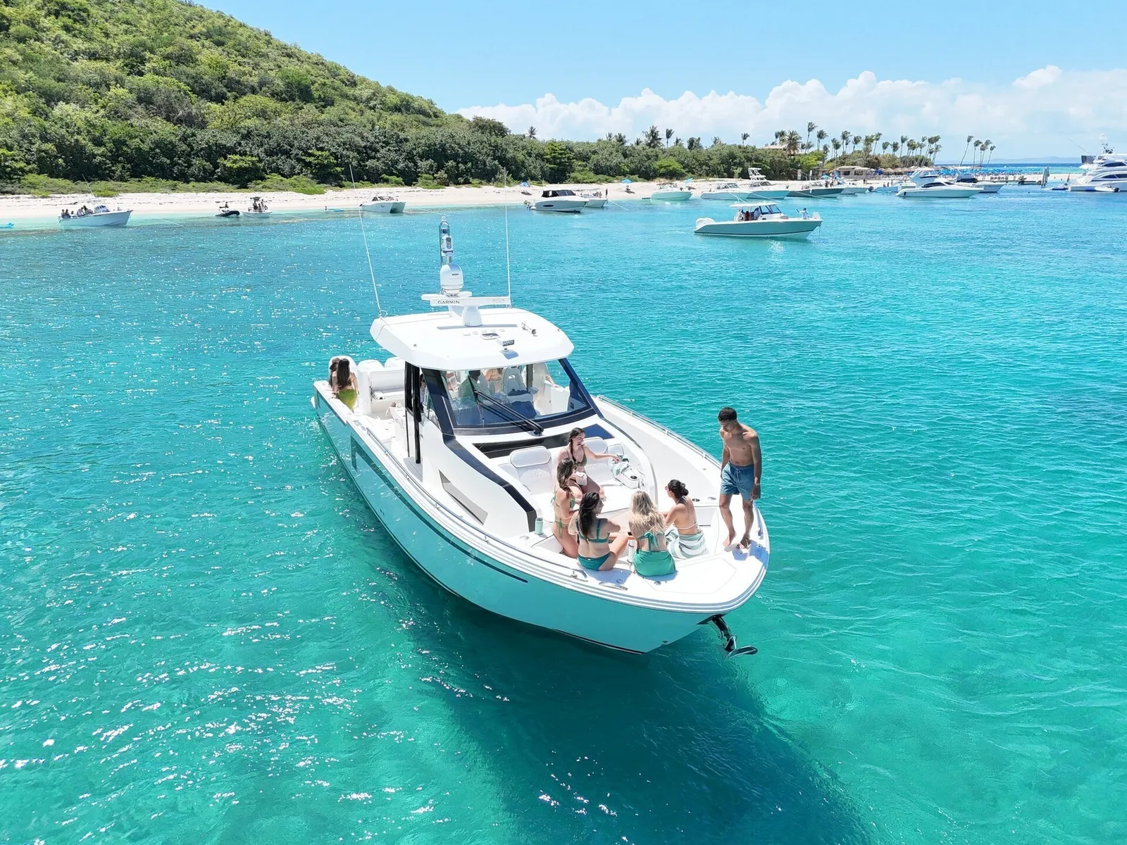 Ocean Alexander 48 sport yacht with guests on the bow — drone shot at sandbar near Fajardo, Caribbean cay backdrop